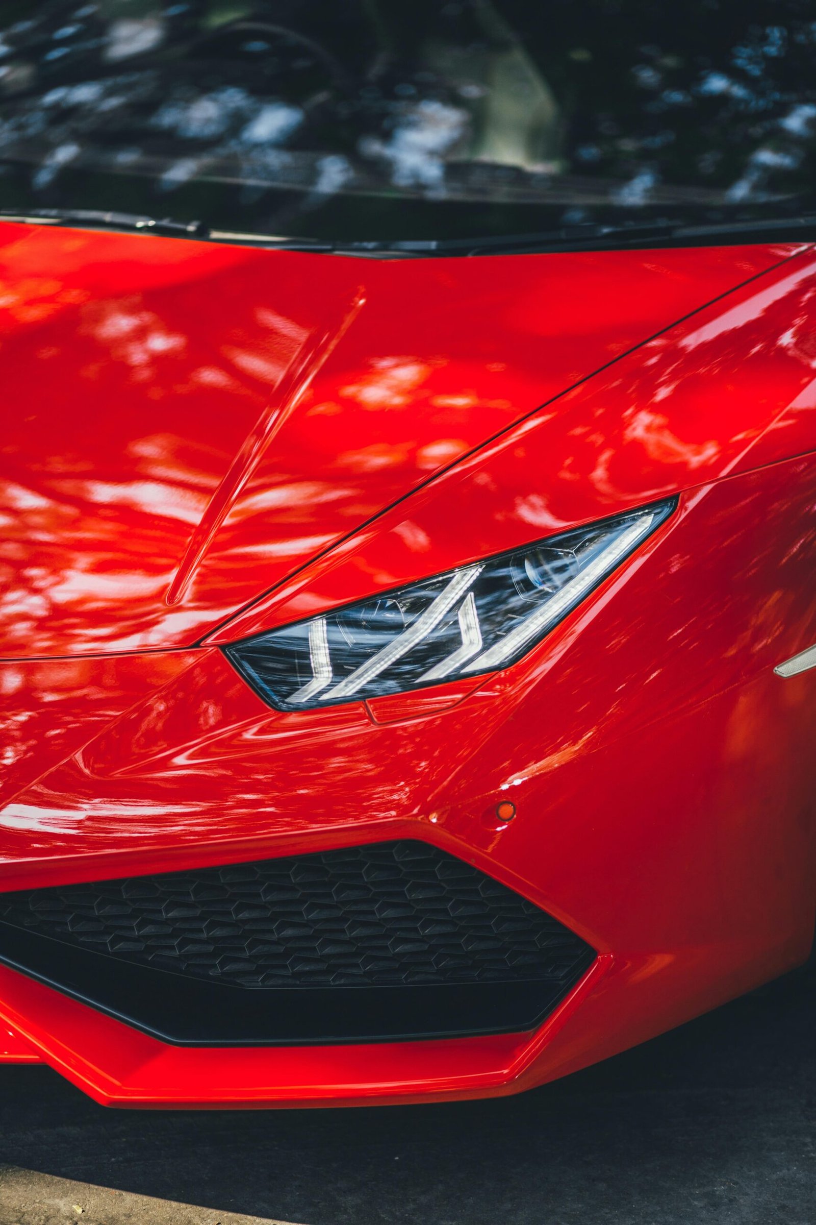 Close-up of a red Lamborghini Huracan parked on a street in New Delhi, India.